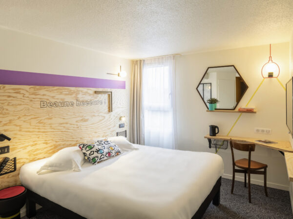 Chambre reposante au design épuré, équipée d'un lit double  et d'une salle de bain privative