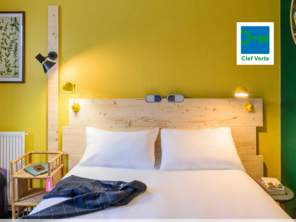 Chambre POP, lit double, aux couleurs chaleureuses et lumineuses, décorée de produits de seconde main