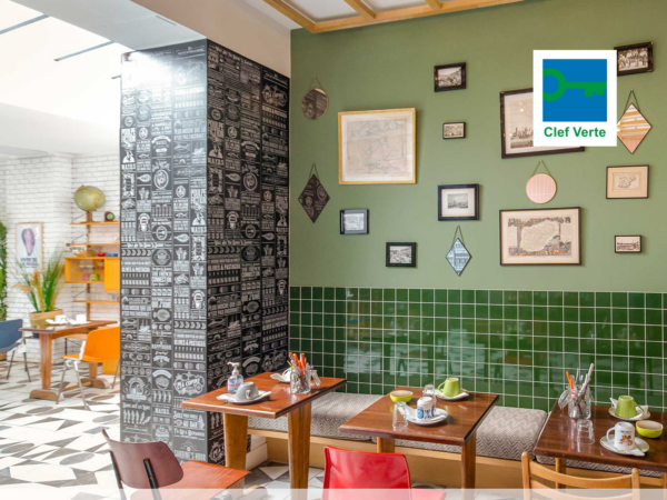 Salle de restauration aux couleurs moderne, décorée de produit chiné et upcyclé et le logo du label clef verte