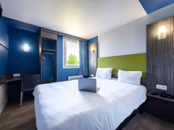 Chambre POP avec un lit double et une décoration conviviale et chaleureuse.